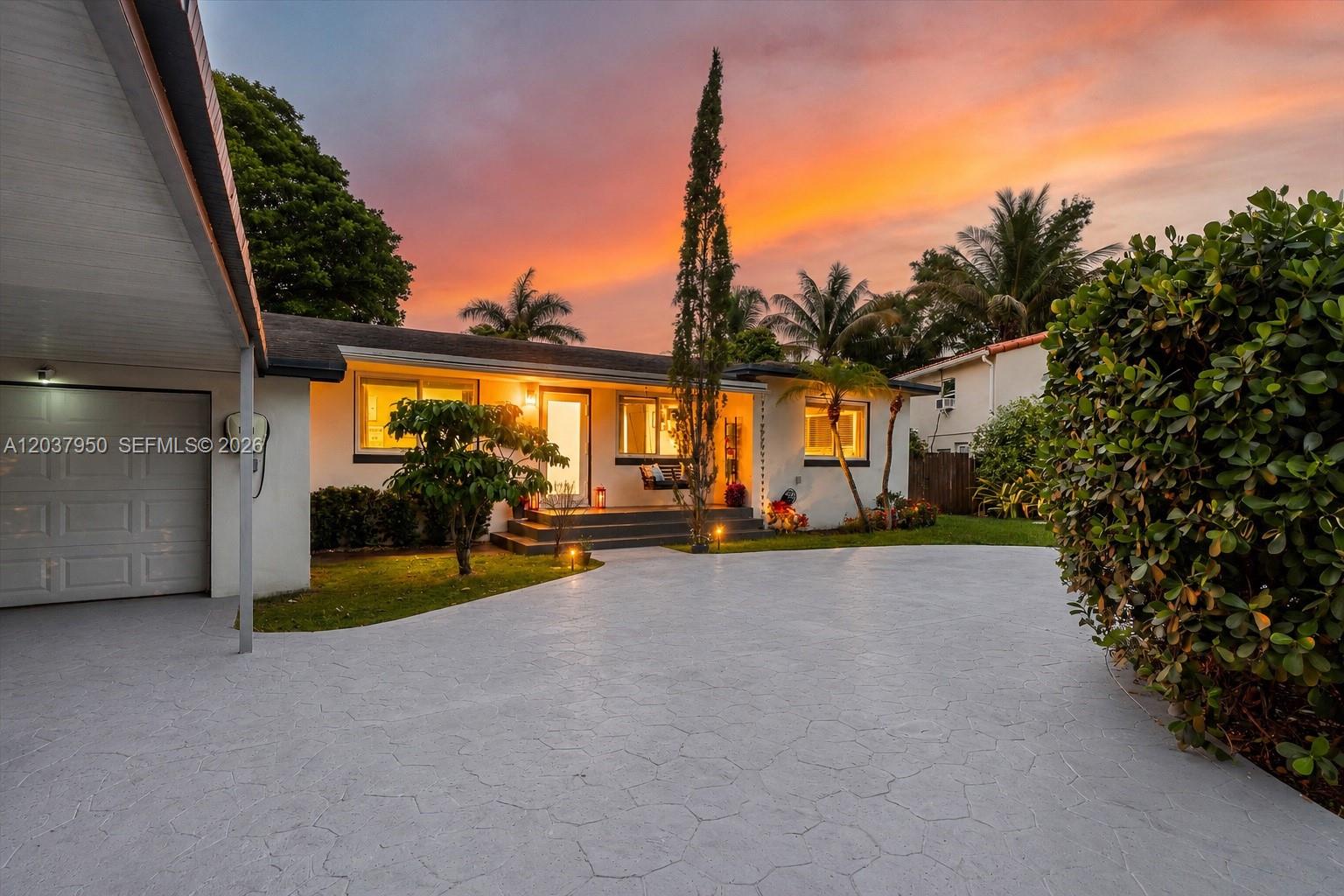 A single-story house with a paved driveway, palm trees, and a sunset sky — 351 NE 117th St, Miami FL 33161, MIAMI, FL