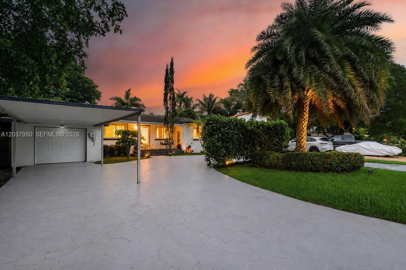 A single-story house with a carport and a palm tree at sunset — 351 NE 117th St, Miami FL 33161, MIAMI, FL
