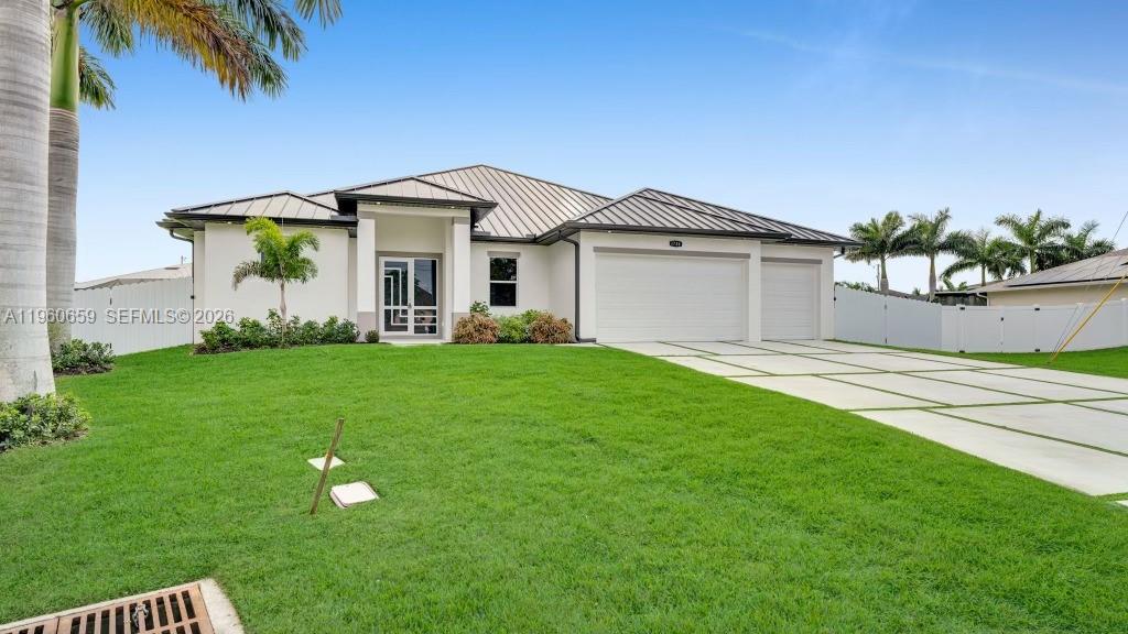 A single-story house with a metal roof, white exterior, and a paved driveway — 1726 SW 36TH TER,, Cape Coral FL 33914, CAPE CORAL, FL