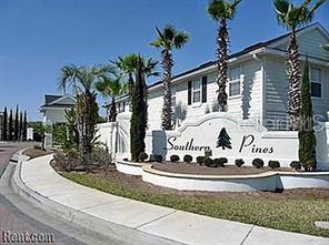 A white apartment building sign for Southern Pines stands near palm trees and a sidewalk — 417 SOUTHERN PECAN CIRCLE UNIT 204, WINTER GARDEN, FL