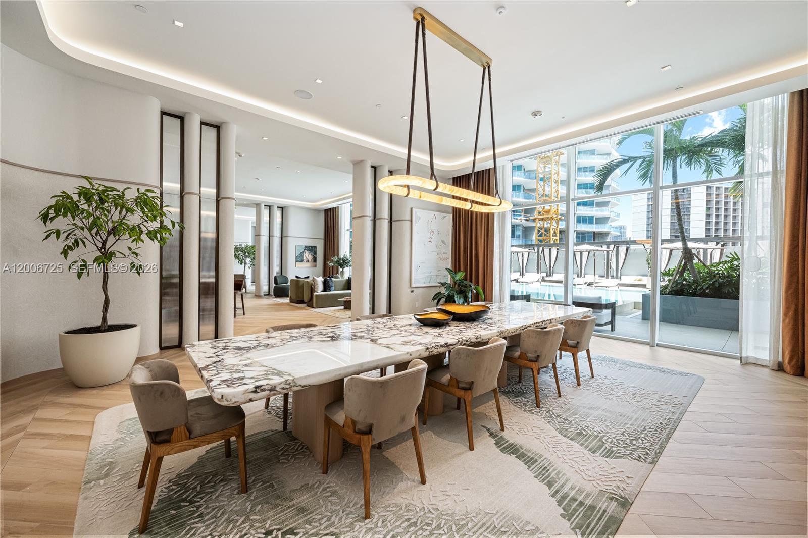 A modern dining room features a long marble table, upholstered chairs, and floor-to-ceiling windows — 77 SE 5 # 1505, Miami FL 33131, MIAMI, FL
