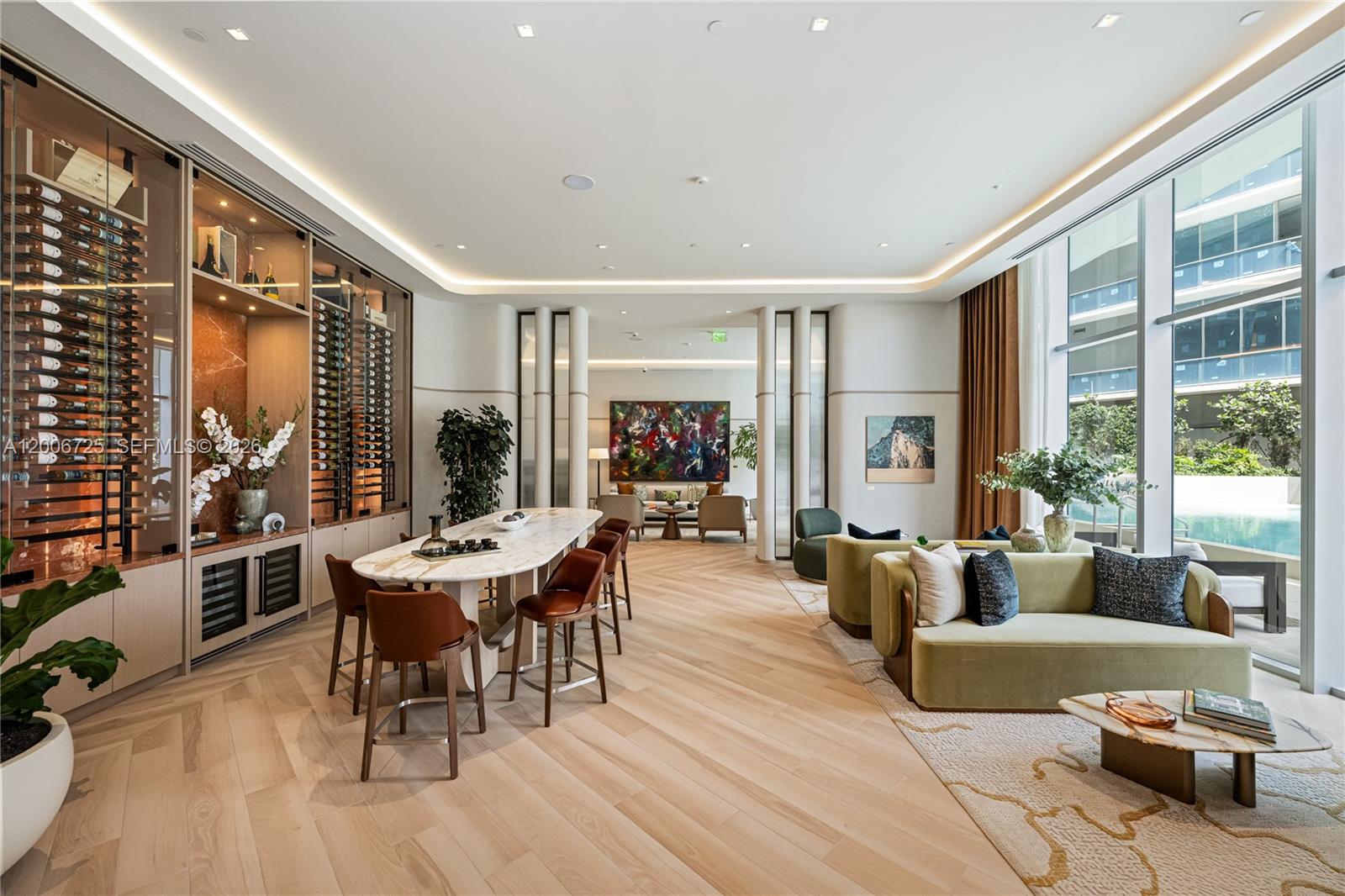 A modern lounge area features a wine wall, marble table, and seating overlooking a pool — 77 SE 5 # 1505, Miami FL 33131, MIAMI, FL