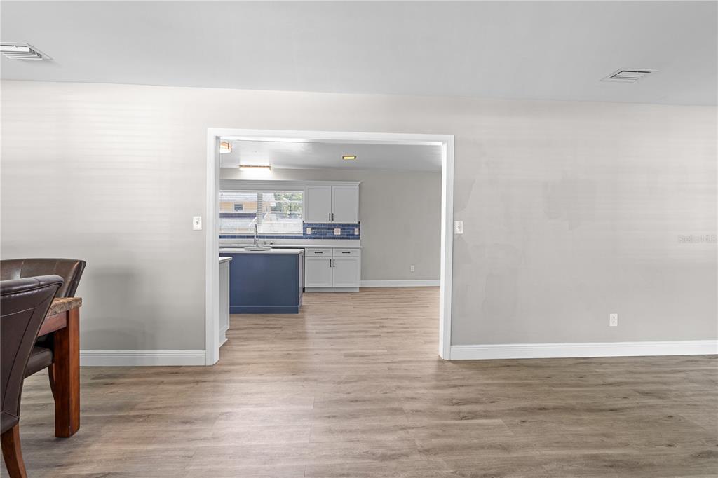 A view from a dining area looking through a doorway into a kitchen with cabinets — 121 NW 29TH ST, GAINESVILLE, FL