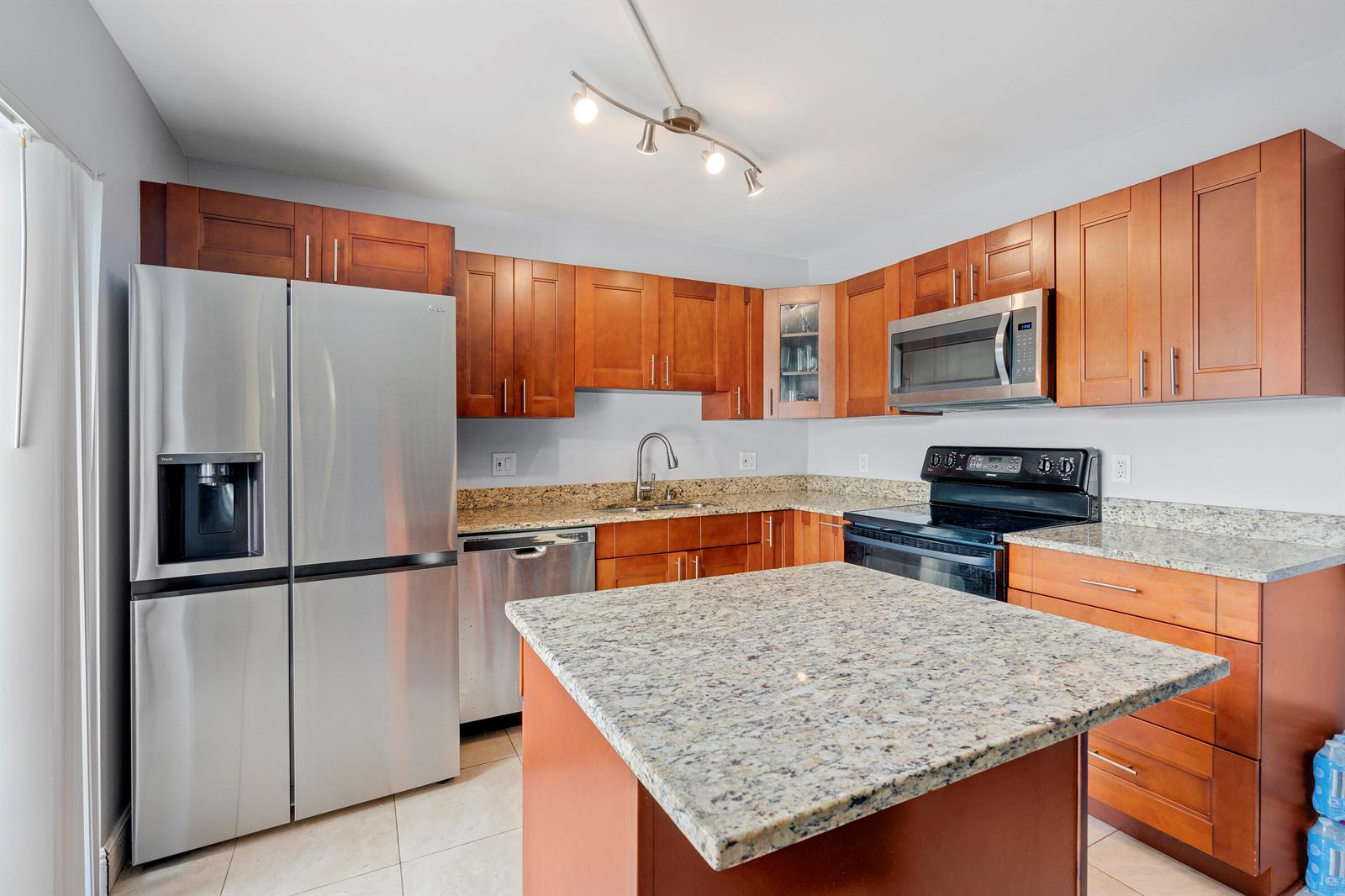 A kitchen features wood cabinets, granite countertops, stainless steel appliances, and a central island — 2244 White Pine Circle # B, FL 33415, FL