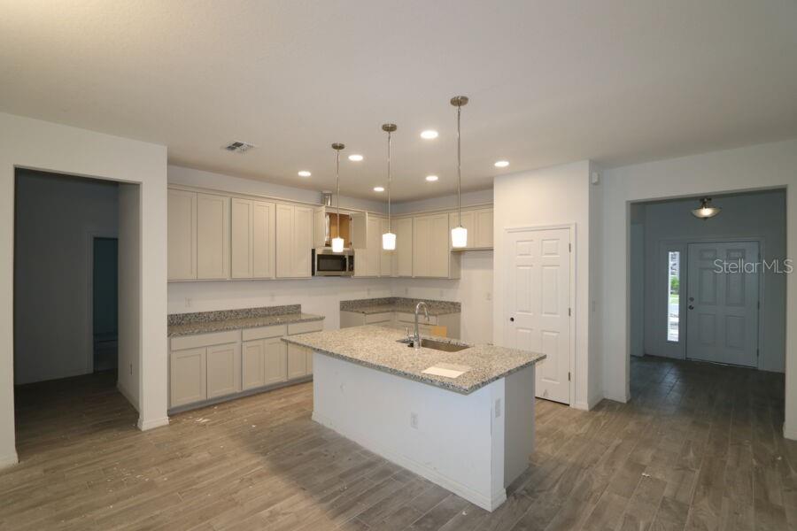 A beige single-story house with a two-car garage, stone accents, and two palm trees — 2952 MARINE GRASS DRIVE, WIMAUMA, FL