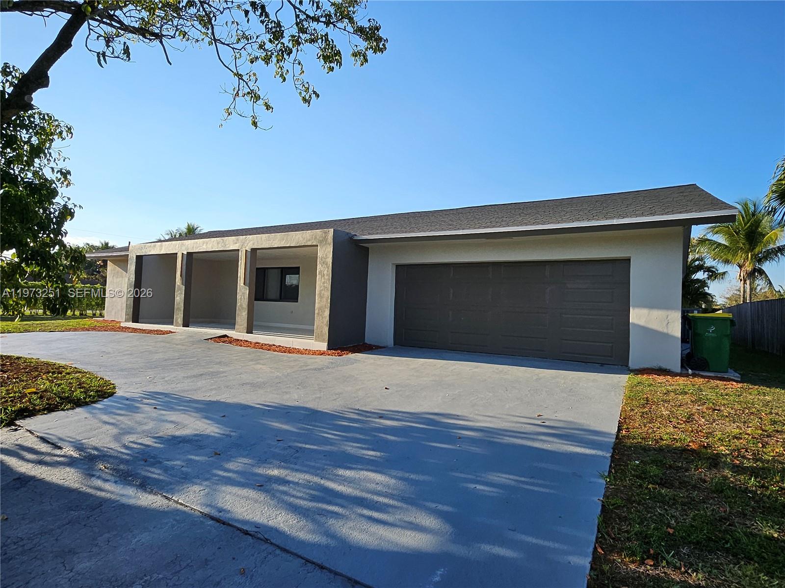 A single-story house exterior features a gray garage, a covered porch, and a concrete driveway — 11761 NW 27th Ct, Plantation FL 33323, PLANTATION, FL
