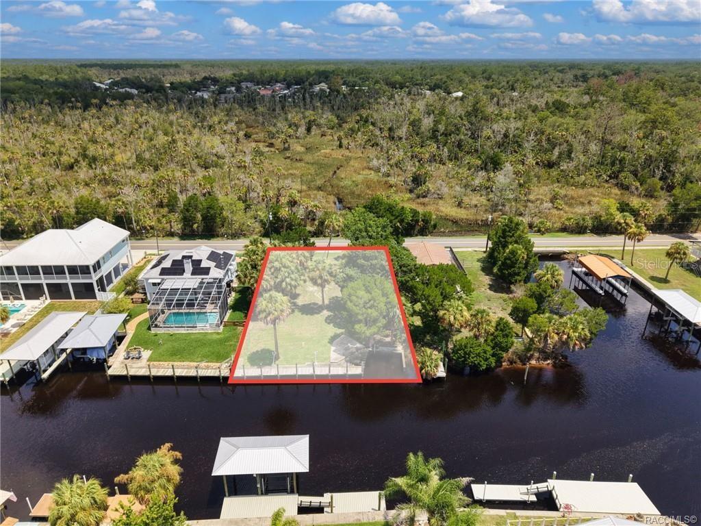 An aerial view shows a vacant waterfront lot outlined in red along a canal — 2020 NW 19TH STREET, CRYSTAL RIVER, FL