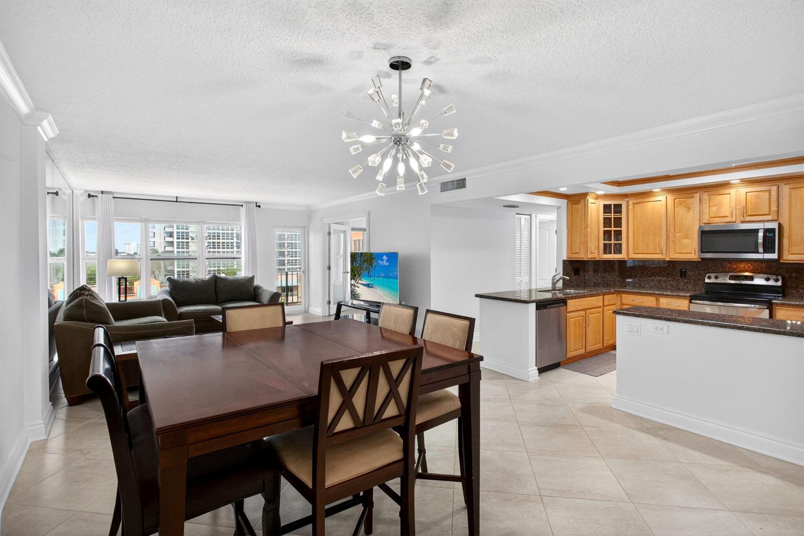 A dining area, living room, and kitchen with wood cabinets and tile floors — 405 N Ocean Boulevard # 507, Pompano Beach FL 33062, POMPANO BEACH, FL