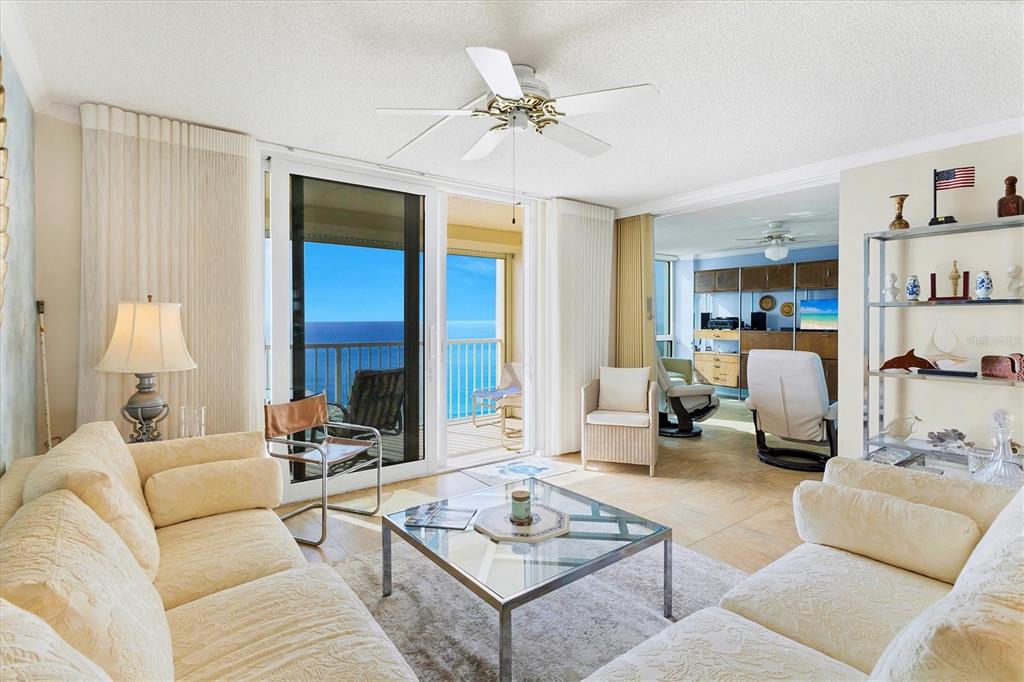 A living room with two beige sofas, a glass coffee table, and a balcony view — 4485 GULF OF MEXICO DRIVE UNIT PH2, LONGBOAT KEY, FL