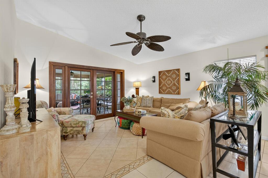 A living room with tile floors, a ceiling fan, and sliding glass doors to a patio — 29 SAN JOSE DRIVE, PALM COAST, FL