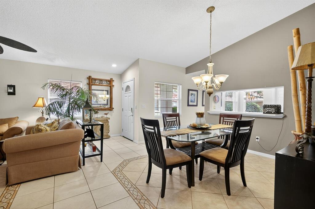 A dining area with a glass table and chairs sits adjacent to a living room — 29 SAN JOSE DRIVE, PALM COAST, FL
