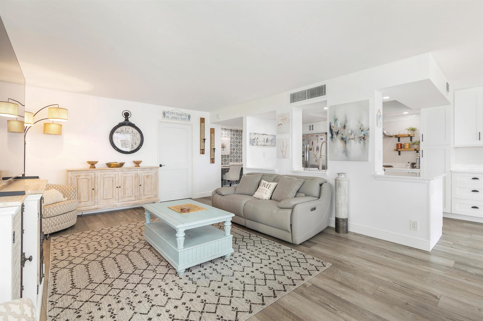 A living room features a grey sofa, a light blue coffee table, and wood-look flooring — 5480 N Ocean Drive, Riviera Beach FL 33404, RIVIERA BEACH, FL