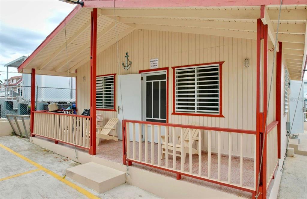 A small house with a covered porch, red trim, and white vertical siding — Calle II 2 3301 COMBATE, BOQUERON, PR
