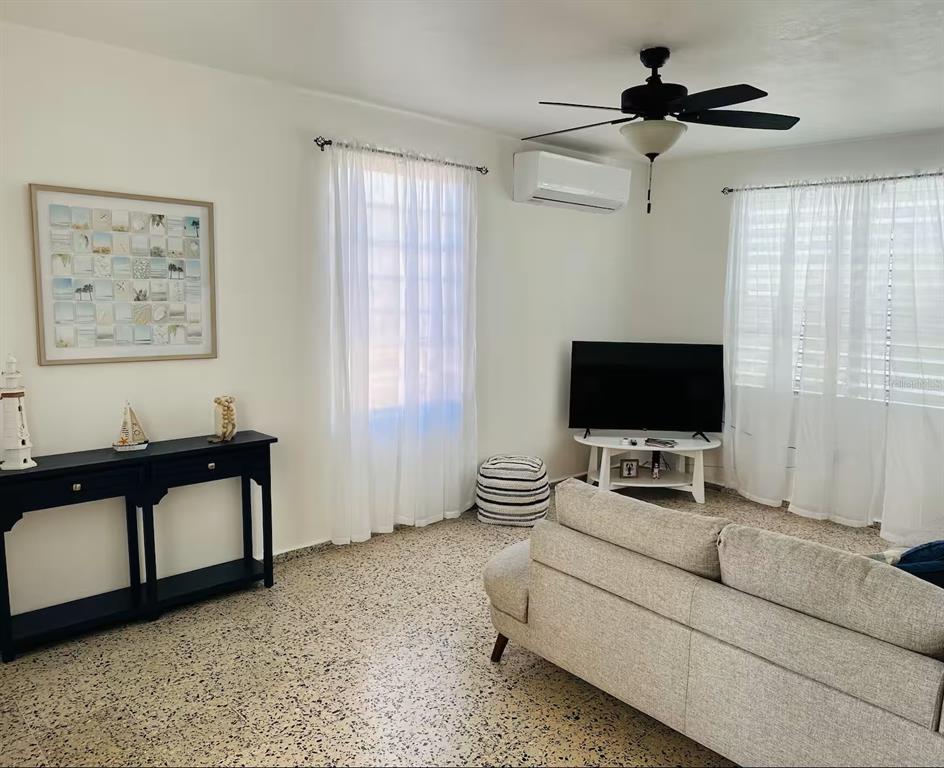 A living room features a light gray sofa, a black console table, and terrazzo flooring — Calle II 2 3301 COMBATE, BOQUERON, PR