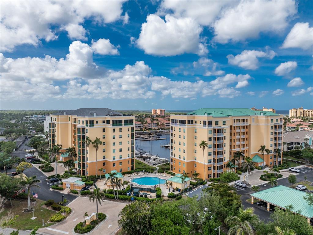 An aerial view of two large apartment buildings with a central pool and boat marina — 2060 MATECUMBE KEY ROAD UNIT 2102, PUNTA GORDA, FL