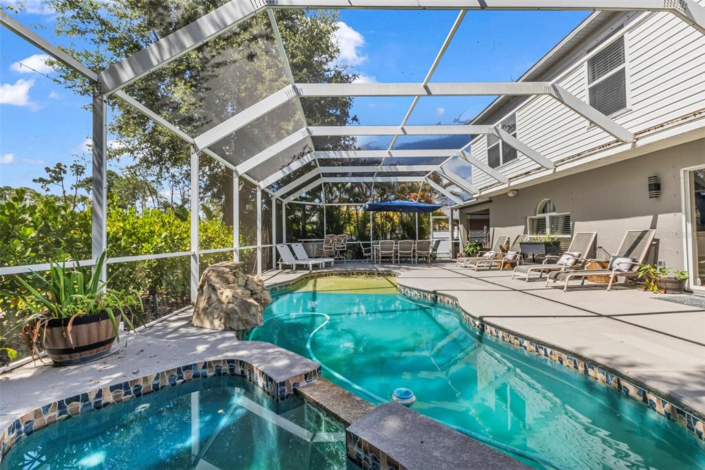 A screened-in patio features a swimming pool, a hot tub, and outdoor lounge furniture — 2837 KALSTED STREET, NORTH PORT, FL