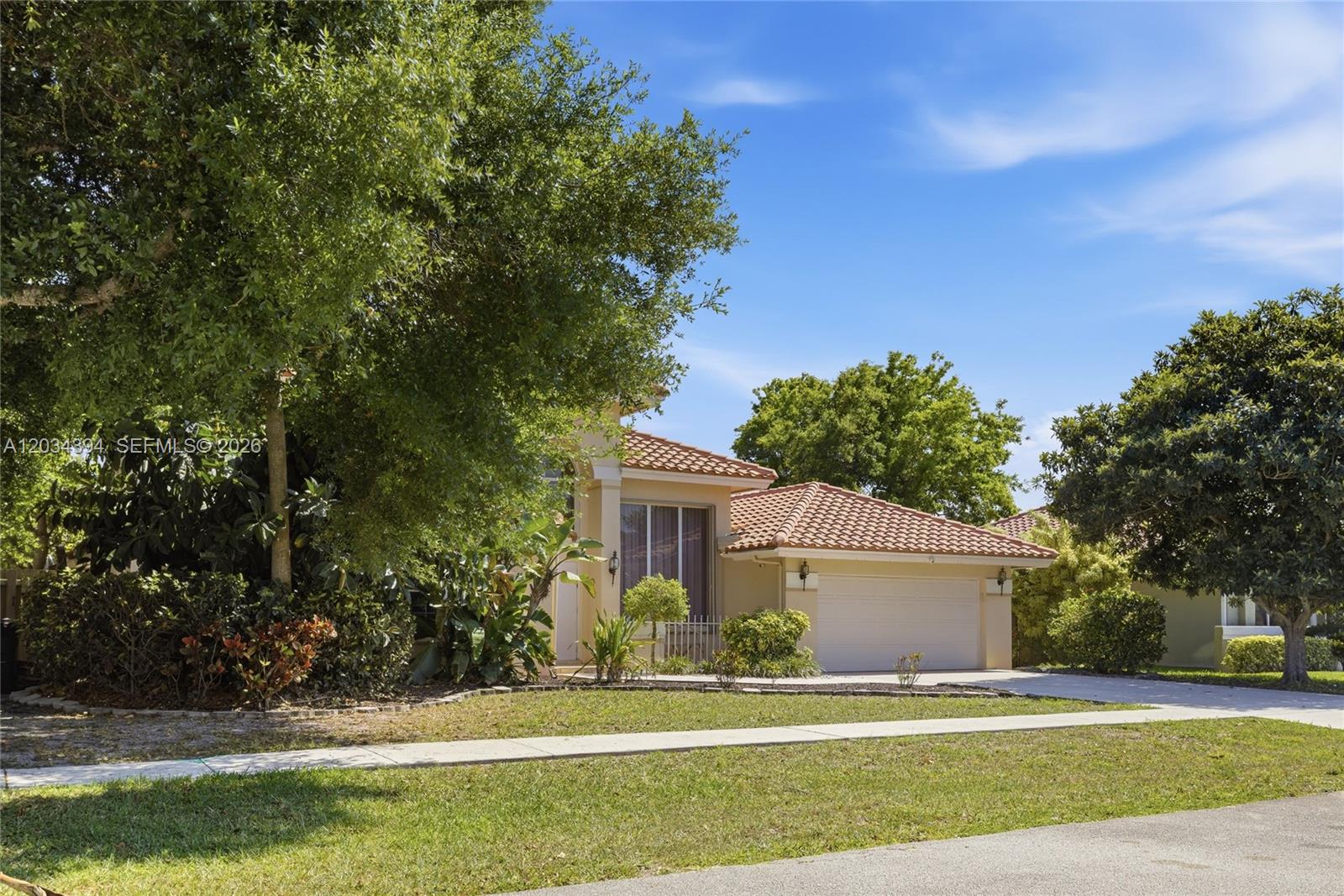 A single-story house with a tiled roof, a two-car garage, and mature landscaping — 9612 N Carousel Cir N, Boca Raton FL 33434, BOCA RATON, FL
