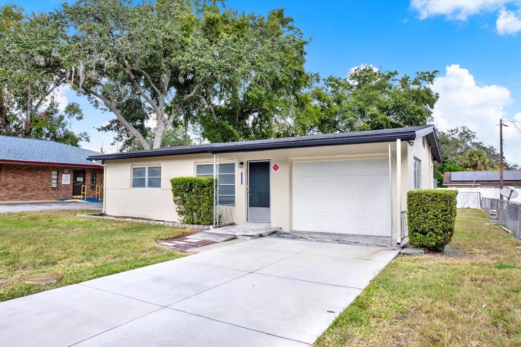 A single-story house with a white garage door, light-colored exterior, and a concrete driveway — 5543 GULF DRIVE, NEW PORT RICHEY, FL