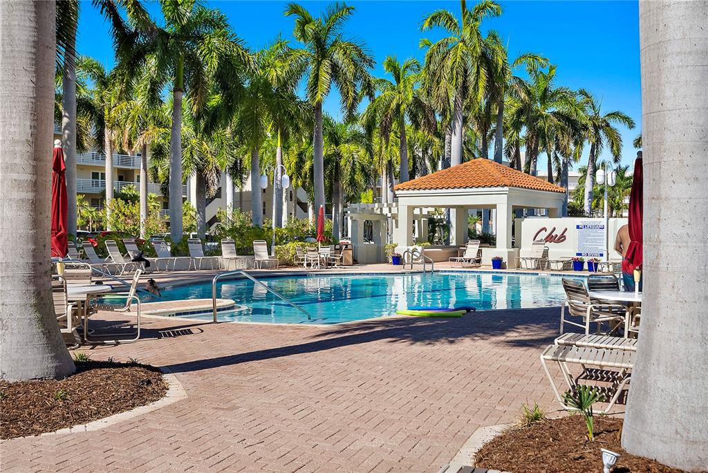 A swimming pool with a surrounding brick patio, lounge chairs, and a covered pavilion — 6085 BAHIA DEL MAR CIRCLE UNIT 272, ST PETERSBURG, FL