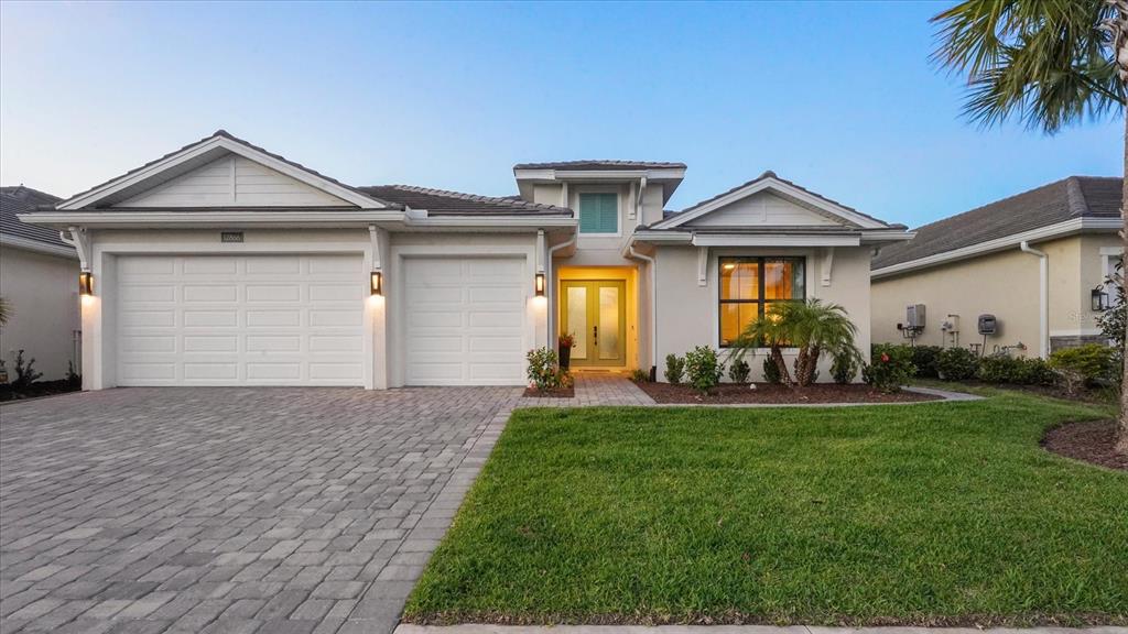 A single-story house with a paved driveway, two-car garage, and a light-colored stucco exterior — 12866 PINNACLE LANE, VENICE, FL