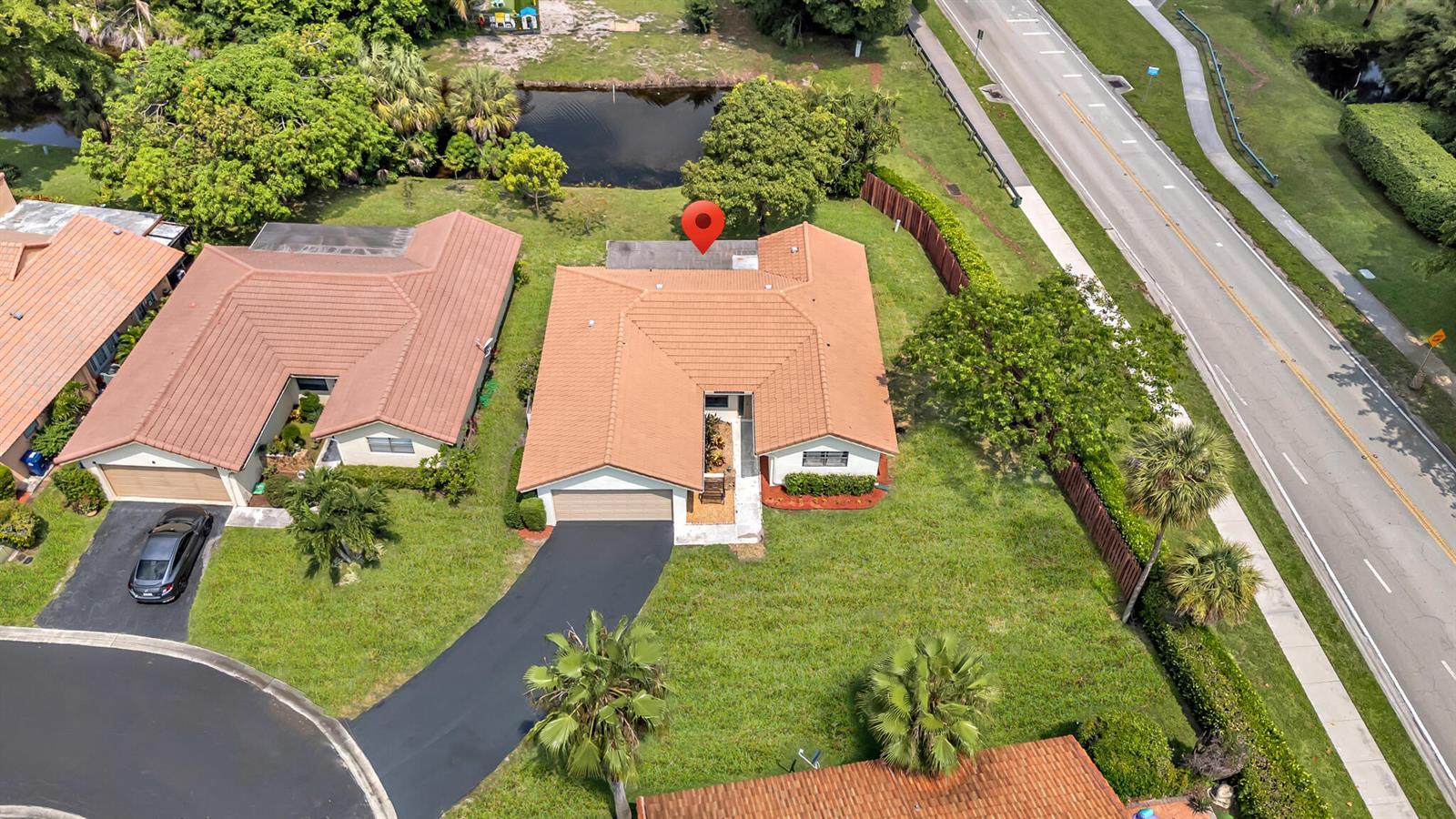 An aerial view shows a single-story house with a brown tile roof and driveway — 1273 Spring Circle Drive, Coral Springs FL 33071, CORAL SPRINGS, FL