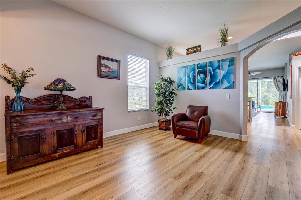 A living area features wood-look flooring, a dark wood sideboard, and a leather armchair — 6462 GOLDEN LEAF COURT, LAKEWOOD RANCH, FL