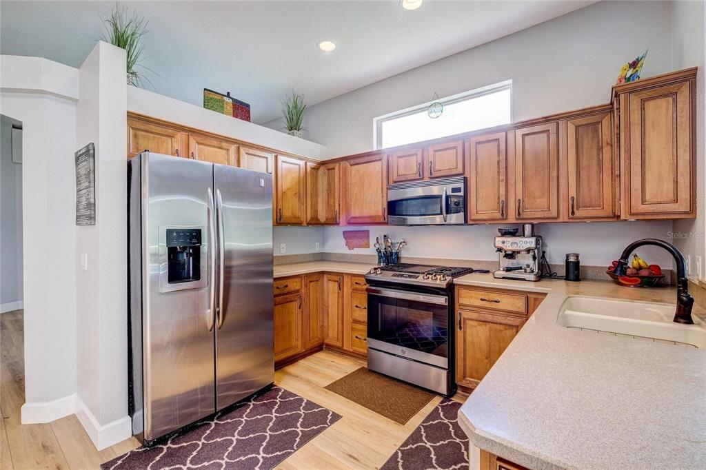 A kitchen with wood cabinets, stainless steel appliances, and light-colored countertops — 6462 GOLDEN LEAF COURT, LAKEWOOD RANCH, FL