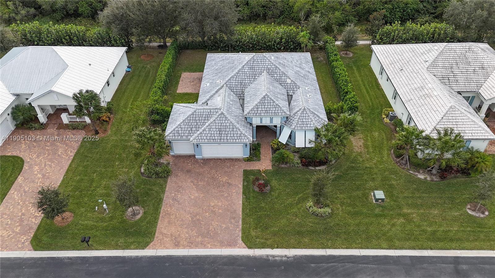 An aerial view shows a single-story house with a gray tiled roof and brick driveway — 2547 Saint Lucia Cir, Vero Beach FL 32967, VERO BEACH, FL