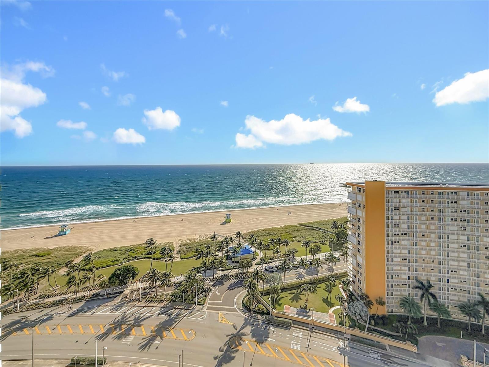 An elevated view of a beach, ocean, and a tall apartment building with palm trees — 405 N Ocean Boulevard # 1918, Pompano Beach FL 33062, POMPANO BEACH, FL