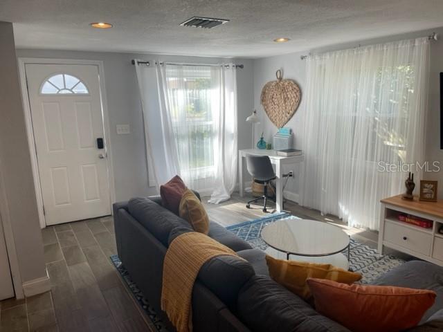 A living room features a grey sectional sofa, a desk, and white curtains — 2765 61ST AVENUE N, ST PETERSBURG, FL