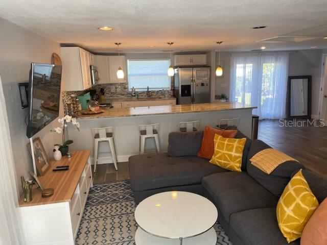 A living room with a sectional sofa and a kitchen featuring a breakfast bar — 2765 61ST AVENUE N, ST PETERSBURG, FL
