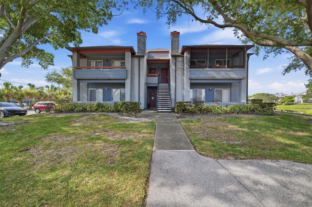 A two-story apartment building with a central staircase, balconies, and a concrete walkway — 10263 GANDY BOULEVARD N UNIT 408, ST PETERSBURG, FL