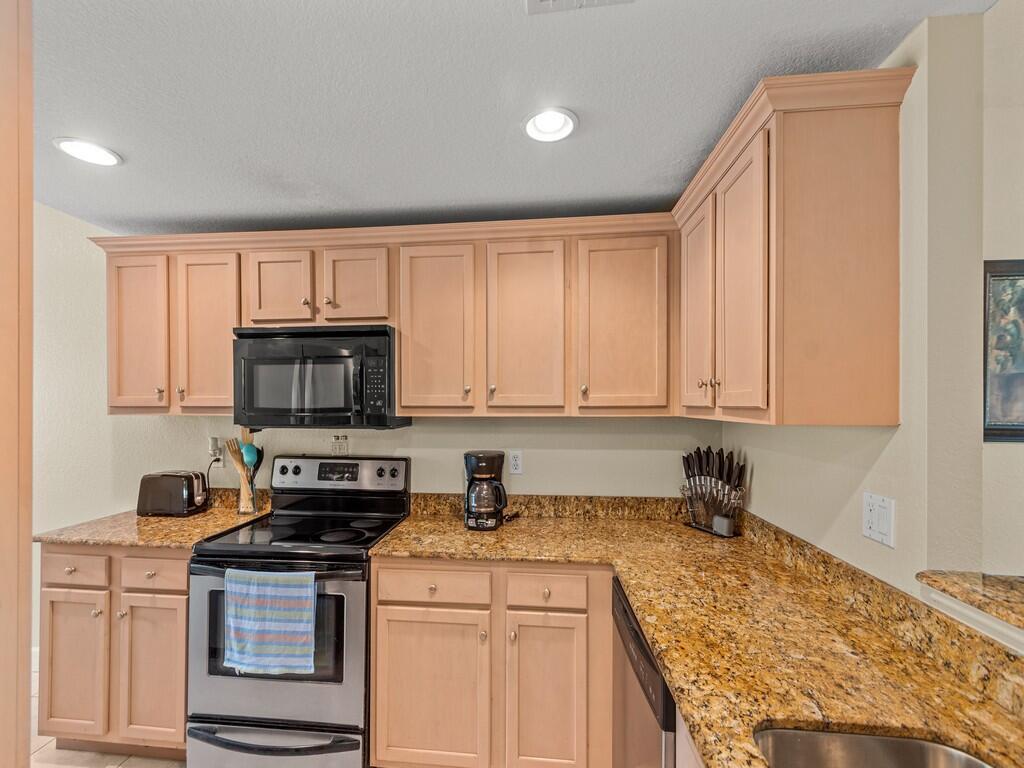 A kitchen with light wood cabinets, granite countertops, and stainless steel appliances — 4210 Gator Trace Avenue # B, Fort Pierce FL 34982, FORT PIERCE, FL