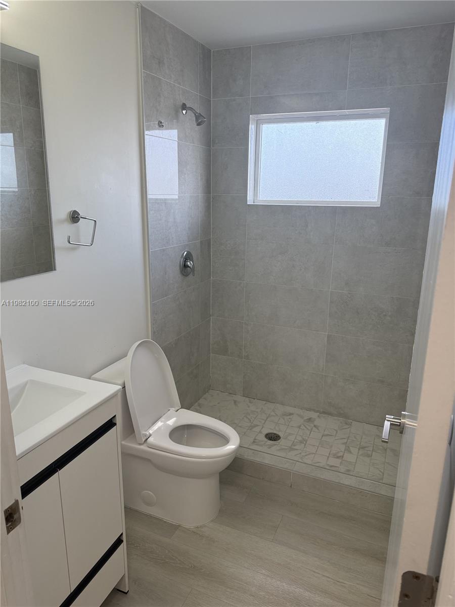 A bathroom features a white vanity, a toilet, and a tiled walk-in shower — 10384 SW 173rd St # 2, Miami FL 33157, MIAMI, FL