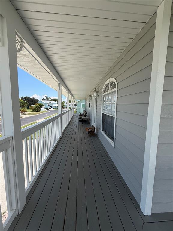 A long, covered wooden porch with white railings overlooks a residential street — 4319 15TH WAY, PALMETTO, FL