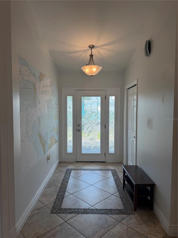 An entryway features a tiled floor with a decorative border, a pendant light, and a map — 4319 15TH WAY, PALMETTO, FL