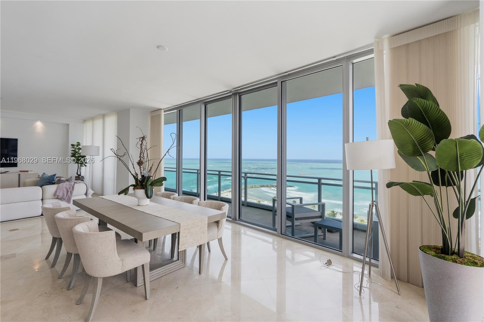A dining room with a large table and ocean views through floor-to-ceiling windows — 10295 Collins Ave # 801, Bal Harbour FL 33154, BAL HARBOUR, FL