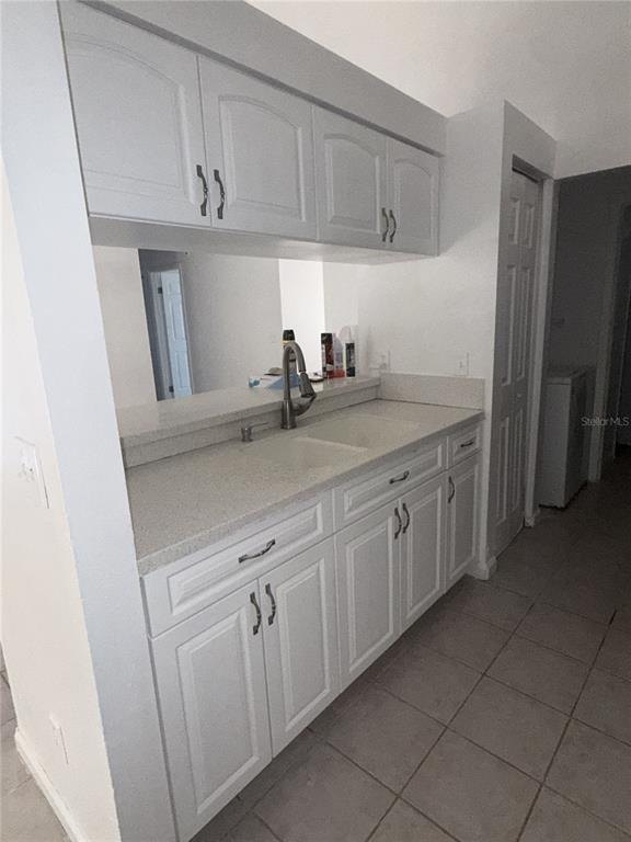 A kitchen features white cabinets, a light-colored countertop, and a double-basin sink — 9213 CAMINO VILLA BOULEVARD, TAMPA, FL