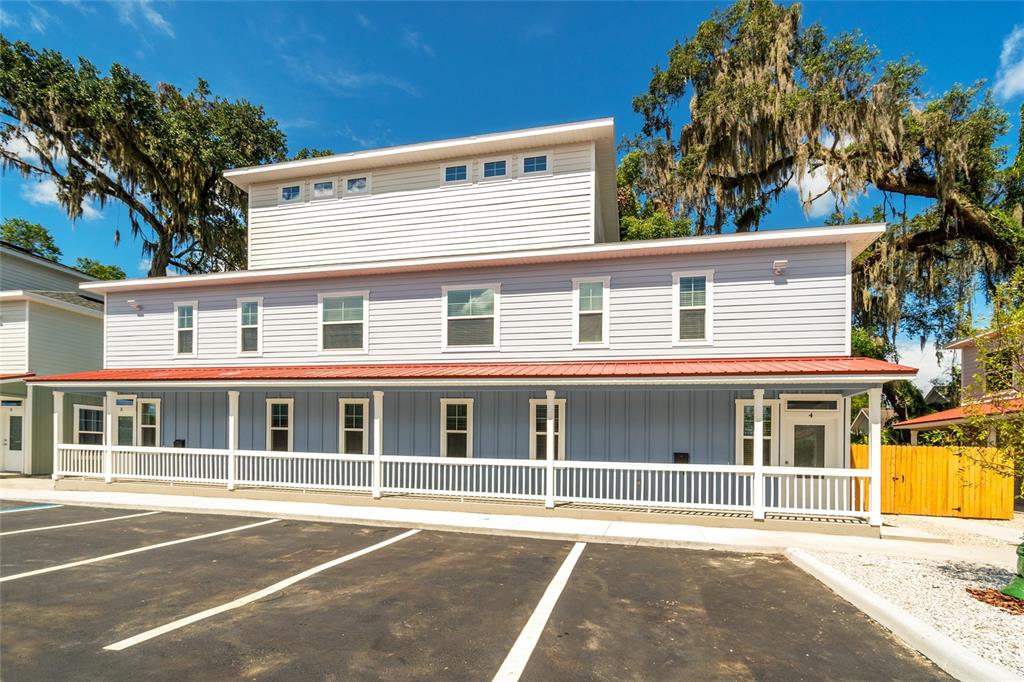 A multi-story building with light blue siding, a red metal roof, and a front porch — 622 NW 3RD AVENUE UNIT 7, GAINESVILLE, FL