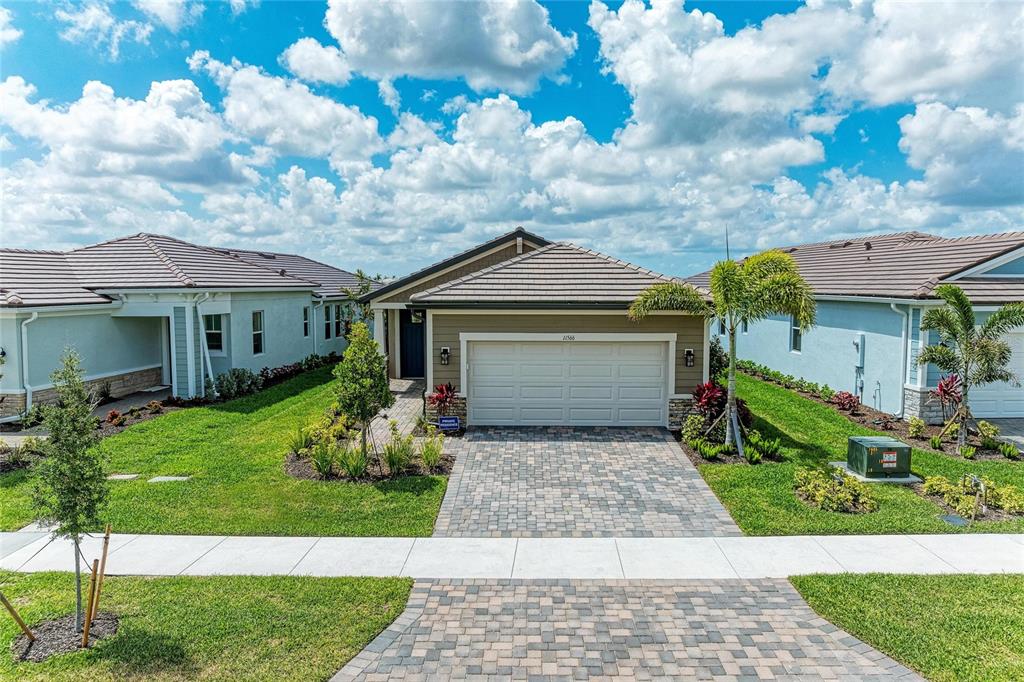 A single-story suburban house with a paved driveway, two-car garage, and a landscaped front yard — 11566 BOUNDLESS TERRACE, VENICE, FL