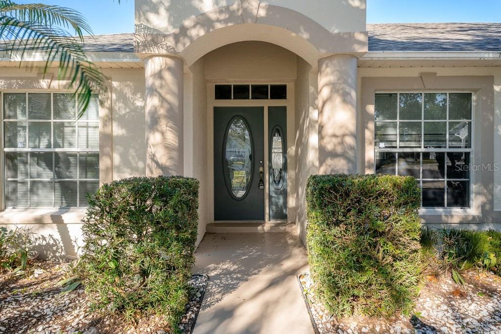 The front entrance of a house features a blue door with oval glass inserts — 4019 GEORGETOWN COURT, ST CLOUD, FL