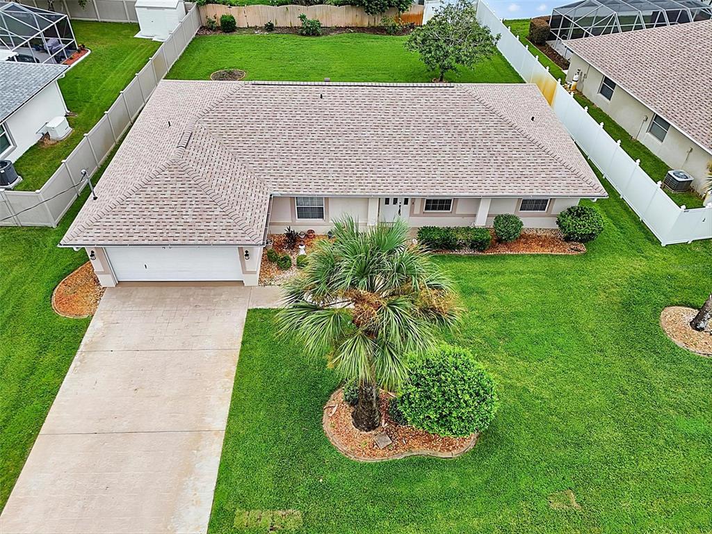 An aerial view shows a single-story house with a shingled roof, driveway, and fenced yard — 6 WILMONT PLACE, PALM COAST, FL