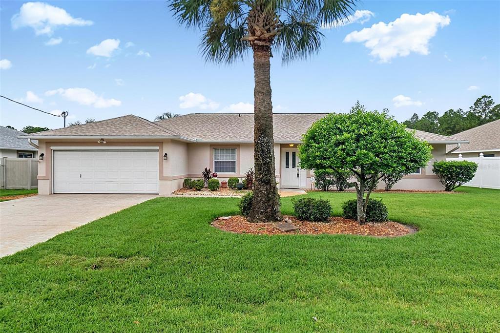 A single-story house with a garage, a palm tree, and a manicured lawn — 6 WILMONT PLACE, PALM COAST, FL