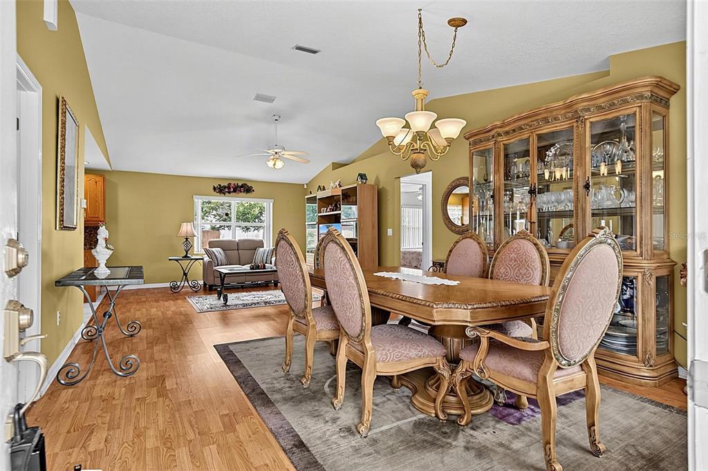 A dining room with a wooden table, upholstered chairs, and a large china cabinet — 6 WILMONT PLACE, PALM COAST, FL
