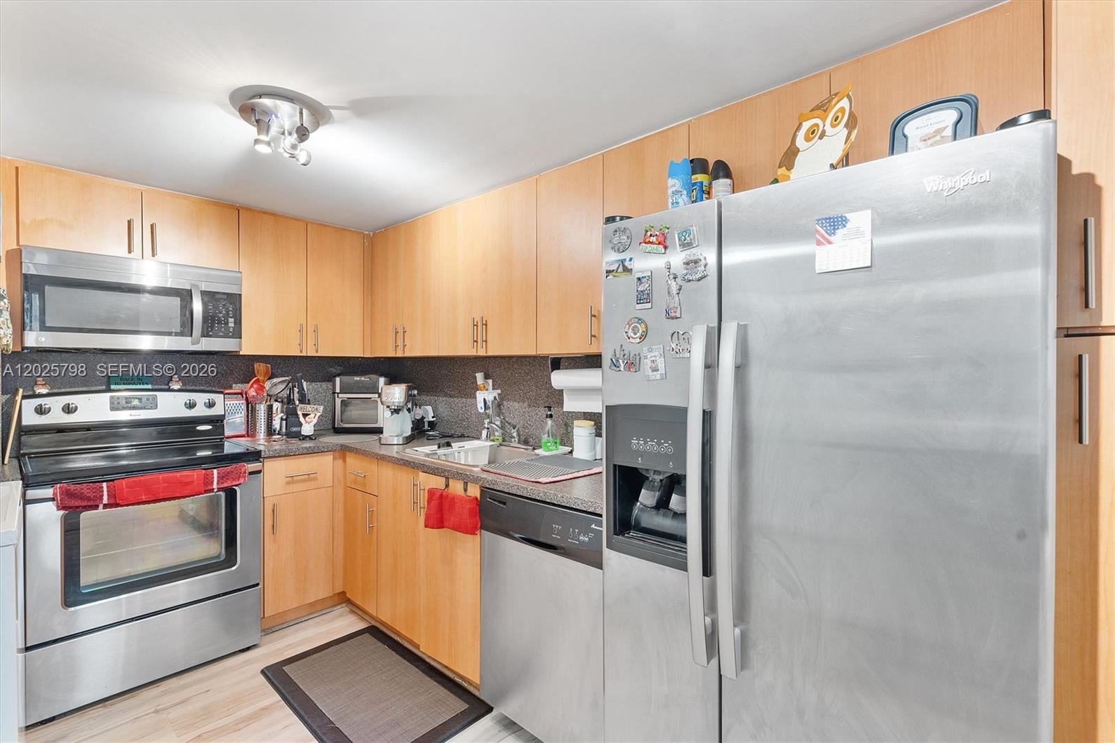 A kitchen features light wood cabinets, stainless steel appliances, and a dark granite countertop — 10000 NW 80th Ct # 2245, Hialeah Gardens FL 33016, HIALEAH GARDENS, FL