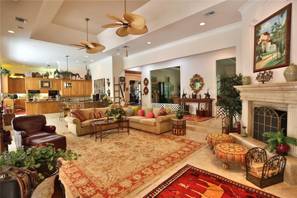 A spacious living room features a fireplace, large area rug, and an open kitchen layout — 1300 SW 43RD PLACE, OCALA, FL