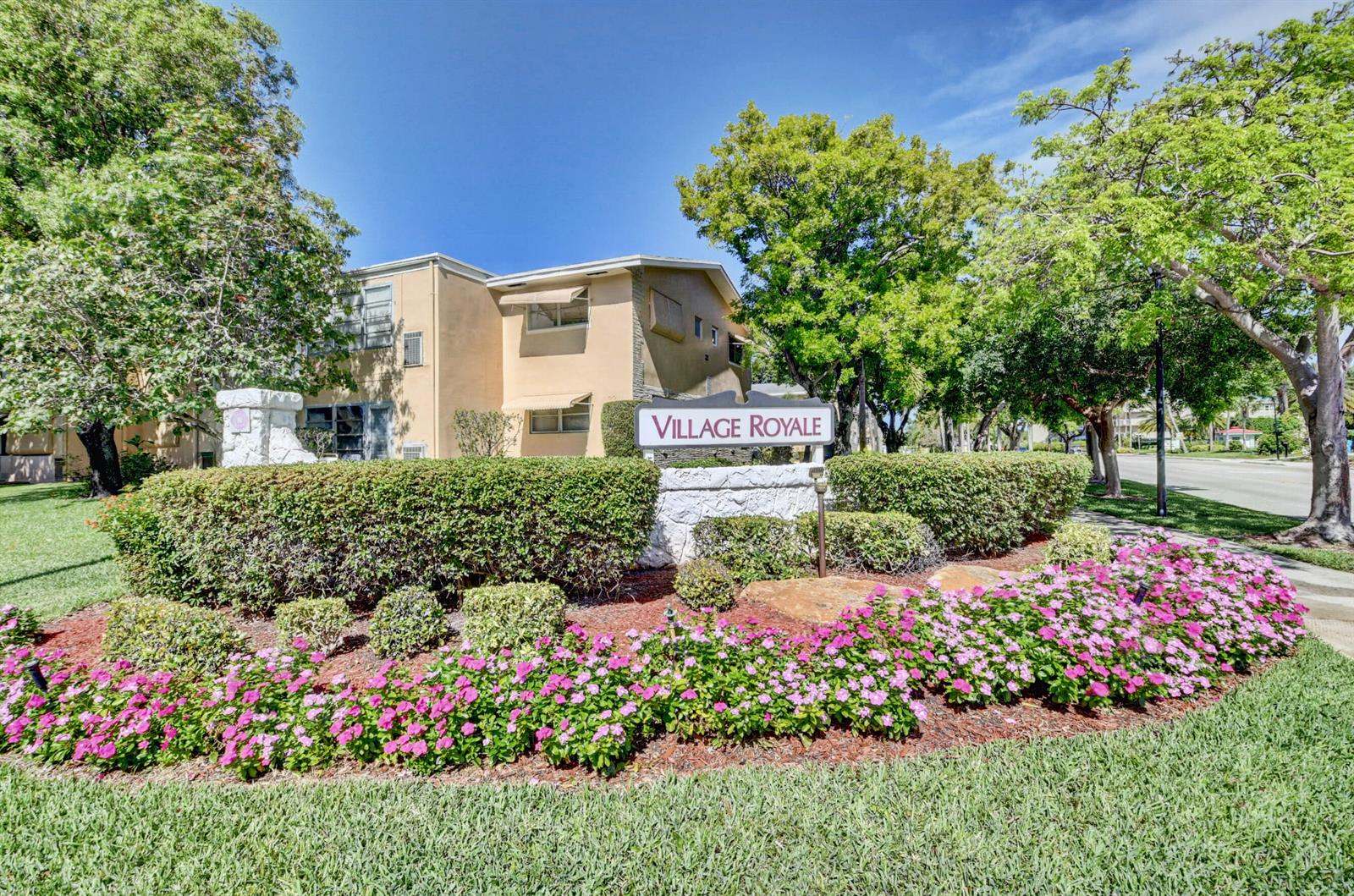 An exterior view of a multi-story apartment building with a Village Royale sign and landscaping — 2152 NE 1st Way # 205, Boynton Beach FL 33435, BOYNTON BEACH, FL