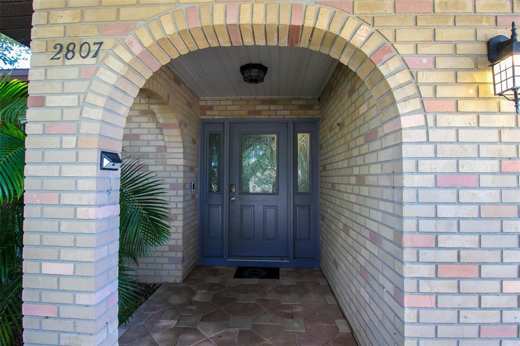 A brick arched entryway leads to a blue front door with glass sidelights and panels — 2807 67TH STREET W, BRADENTON, FL