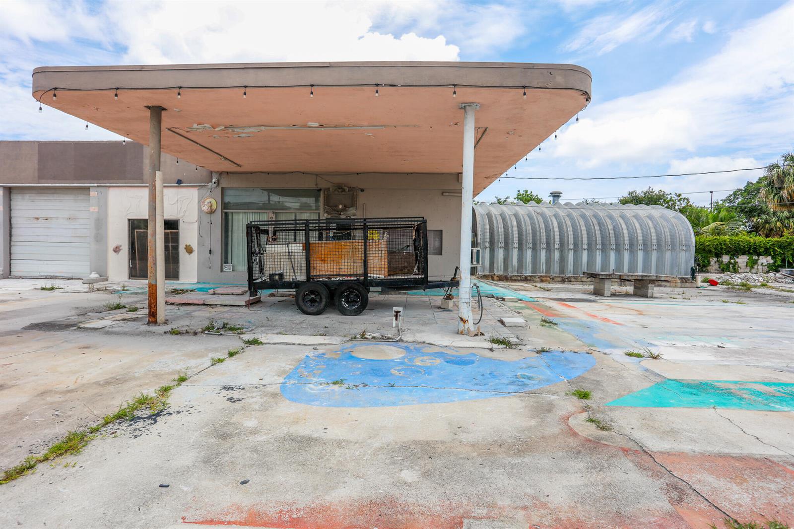 An abandoned gas station with a large canopy and a utility trailer parked underneath — 1620 S Dixie Highway, Pompano Beach FL 33060, POMPANO BEACH, FL