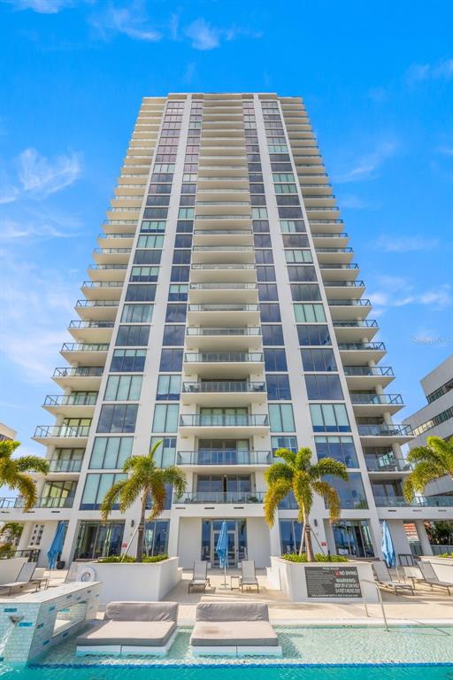 A tall residential high-rise building features balconies and a swimming pool in the foreground — 301 1ST STREET S UNIT 1505, ST PETERSBURG, FL